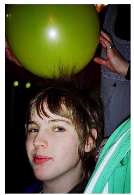 A balloon rubbed on hair picks up electrons, charging the balloon and the hair oppositely.