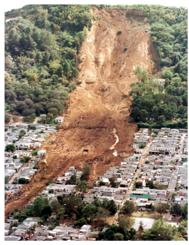 Aerial photograph of a landslide that swept down a hillside into a town below.