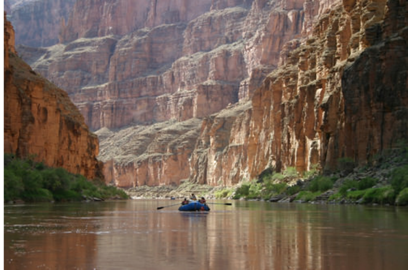 A river cutting through sedimentary rock layers, forming a canyon.